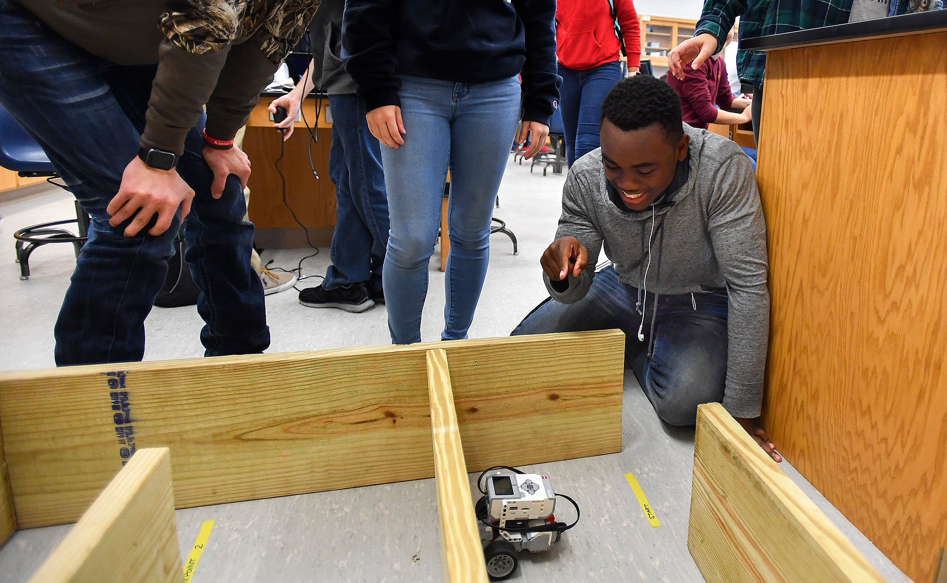 Students pilot a robot through a wooden maze