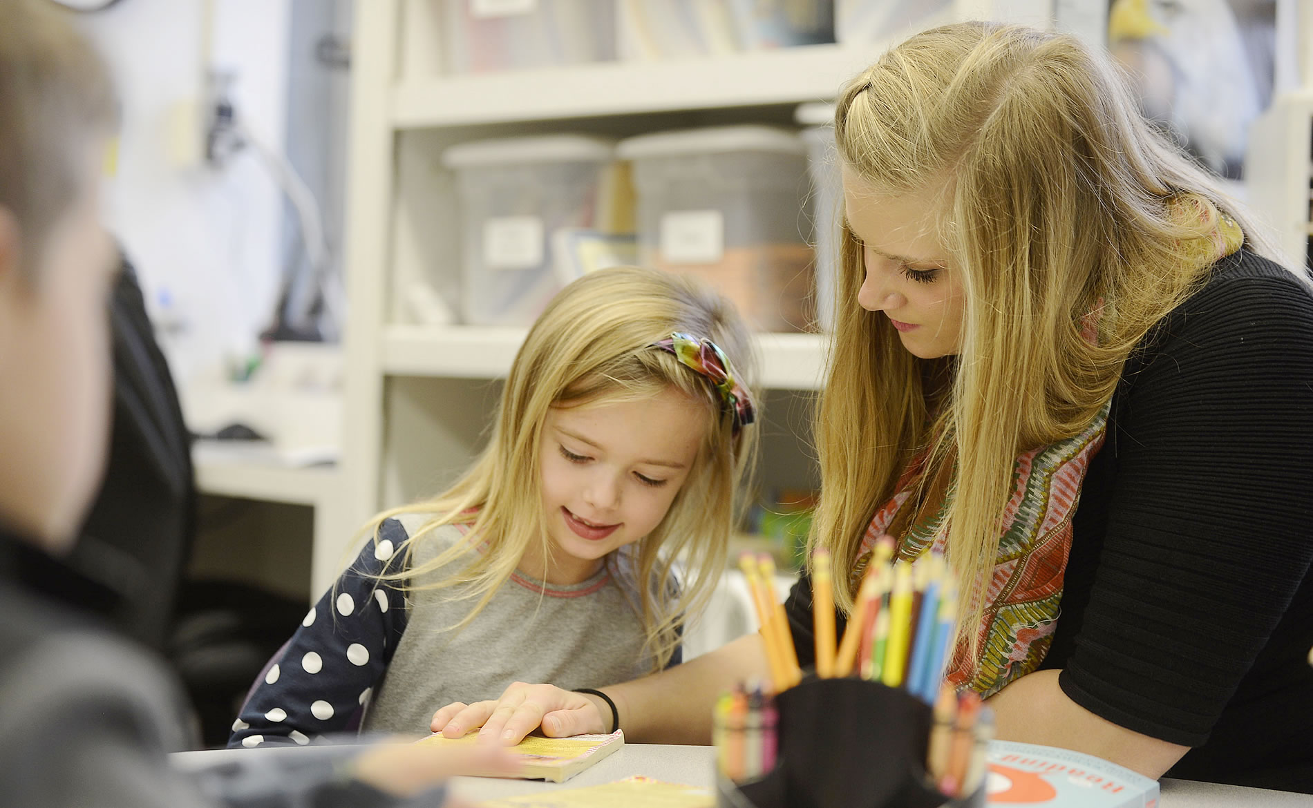 College student coloring with a child