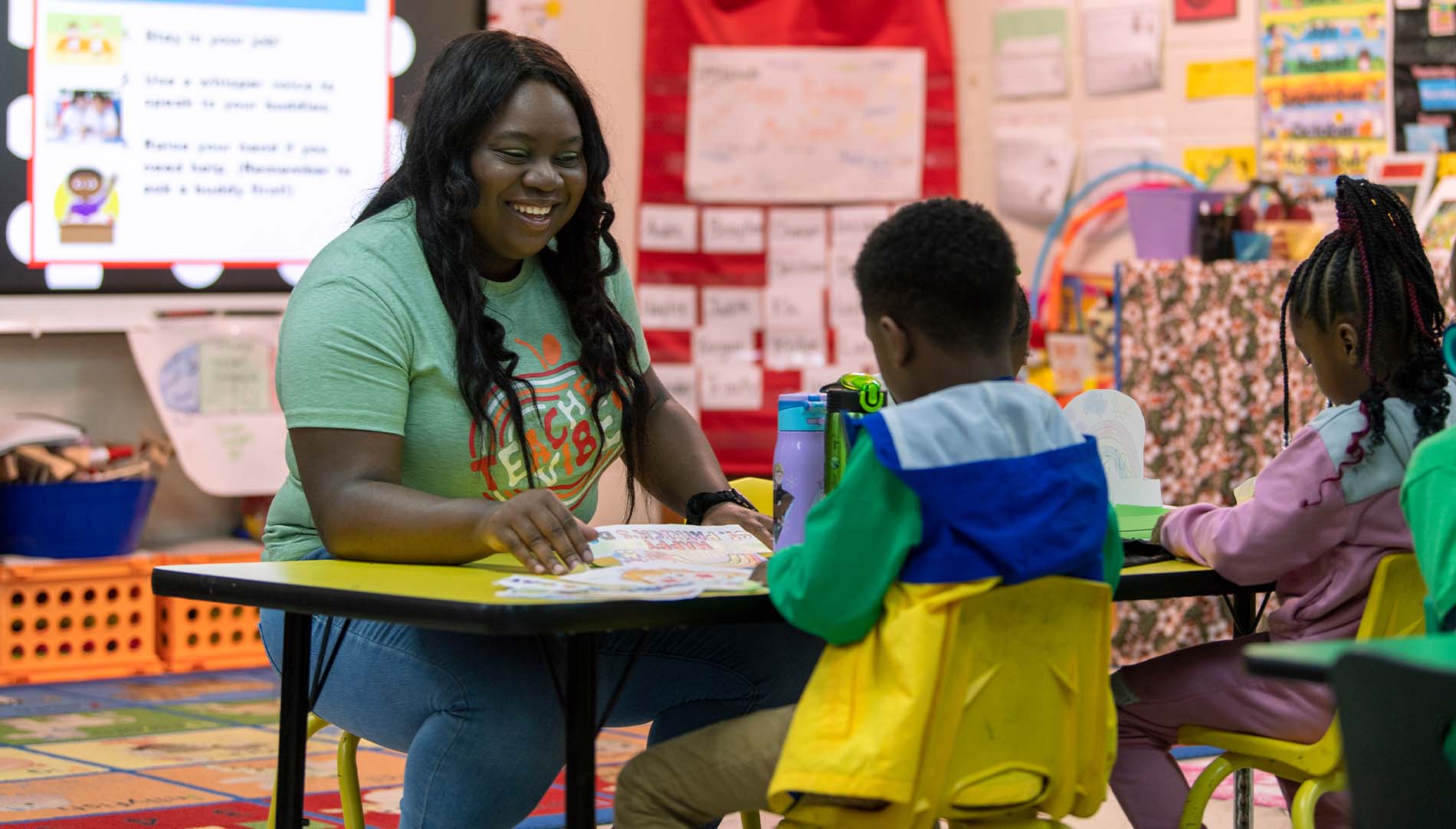 student teacher working with two young students