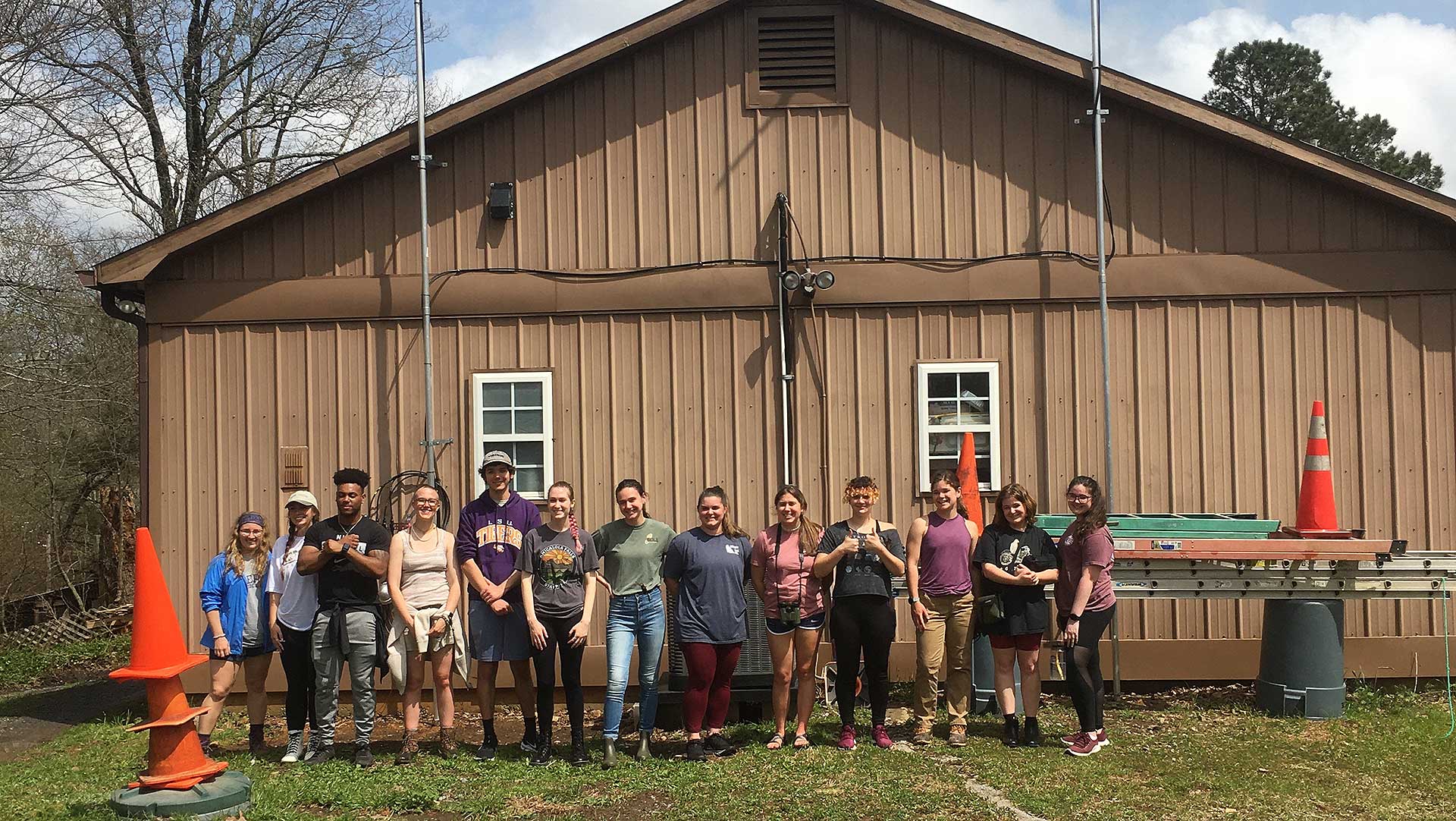 Group of Biology students in front of a brown building