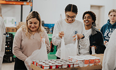 group of female students packing food items in bags